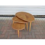 An Ercol nest of three pebble tables in light elm and beech.