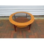 A circular glass top coffee table by Remploy