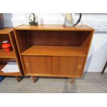 A Danish teak twin door cabinet with open bookcase above, raised on tapering legs,
