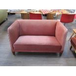 A Danish 1940's small twin seater sofa, pink velour upholstery, raised on tapering square legs,
