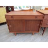 A Danish teak cabinet with single drawer above twin sliding doors, raised on tapering legs,