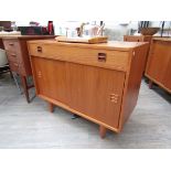 A Danish teak cabinet with single drawer above twin sliding doors, raised on tapering legs,