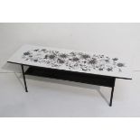 A 1960's coffee table with formica top decorated with foliate design, iron base. 113cm x 37.