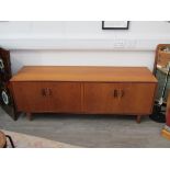 A G-Plan teak low side cabinet with four cupboard doors, shelved interior,