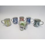 ANDREW HAZELDEN - A set of six Aldermaston Pottery mugs in various colours. Painted marks to bases.