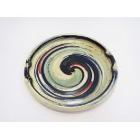 A large studio pottery dish decorated in colourful enamels impressed potters seal to centre glazed