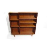 A Danish teak open bookcase raised on tapering legs,