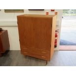 A Danish oak tall cabinet with twin doors, shelved interior, two drawers below,