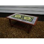 A teak coffee table with inset tile panel top decorated with sunflower design 83cm x 52cm x 37cm