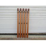 A wooden slat and metal wall coat stand.