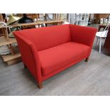 A Danish 1940's twin seater sofa, original red wool upholstery, short square stained oak legs,