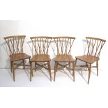 A set of four Ercol Chiltern Candlestick chairs with shaped seats in light elm and beech