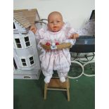 A plastic doll in metamorphic high chair