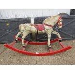 A painted wooden and straw filled rocking horse on bowed rocker,