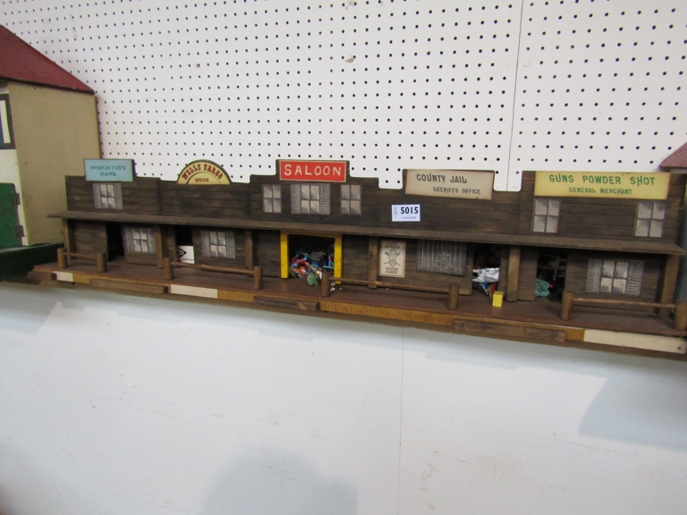 A wooden toy American Western street arcade with cowboys and Indians plastic figures