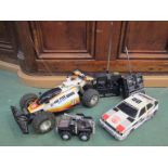 Two 1980's RC cars and remotes and a Rough Riders truck