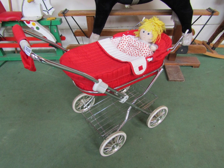 A vintage doll's pram and doll