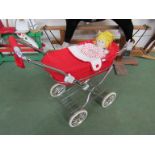 A vintage doll's pram and doll