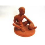 A terracotta day figure of a seat man working