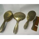 A silver four piece dressing table set including hand mirror, vacant catouches,
