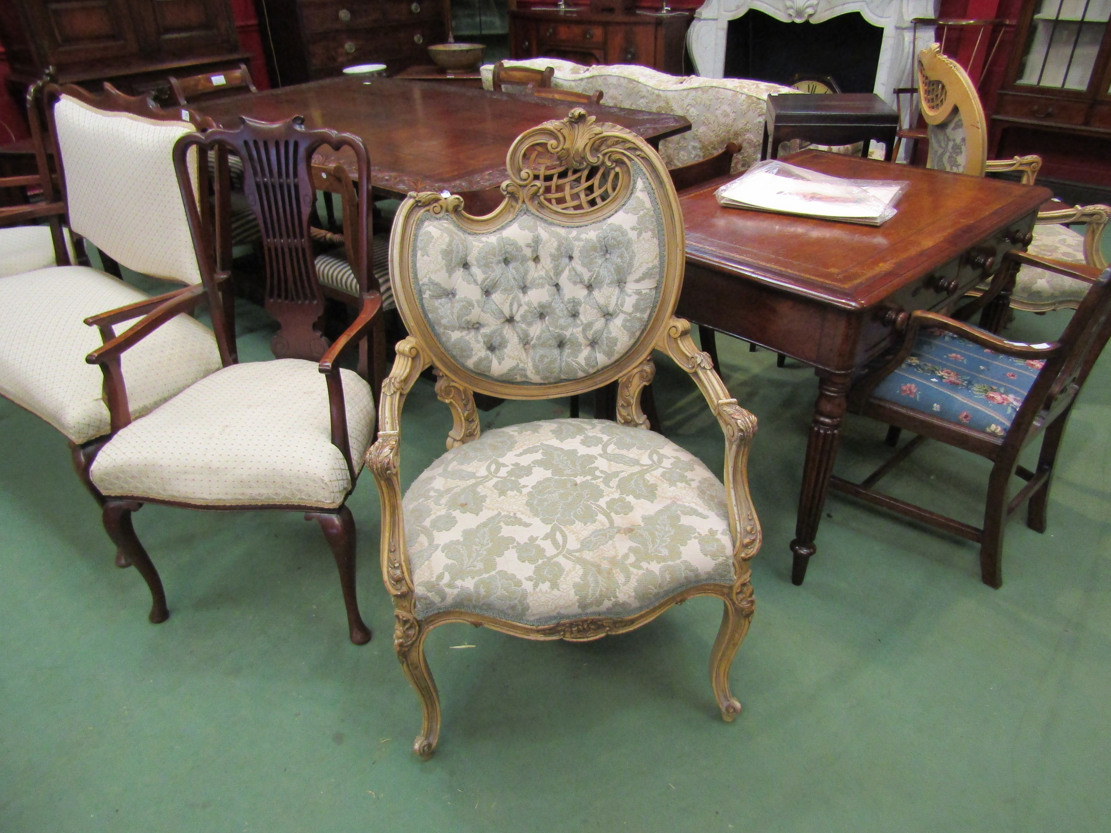 A pair of Rococo style decorative elbow chairs with floral upholstery