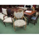 A pair of Rococo style decorative elbow chairs with floral upholstery