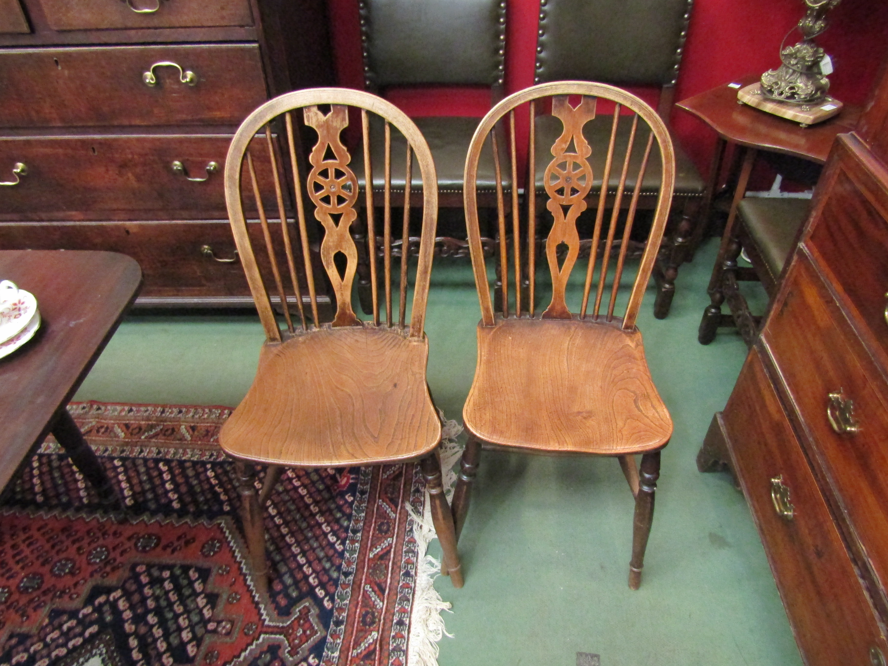 A set of four elm seated wheel and stick back chairs