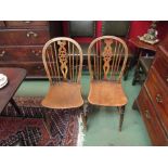 A set of four elm seated wheel and stick back chairs