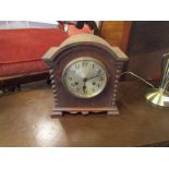 A 1930's oak mantel clock with bobbin design sides,