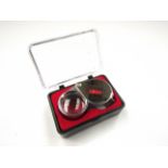 A cased 30x metallic jeweller's loupe