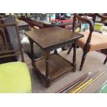 An early 20th Century oak two tier table, turned legs,