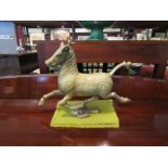 A brass figure of a galloping horse