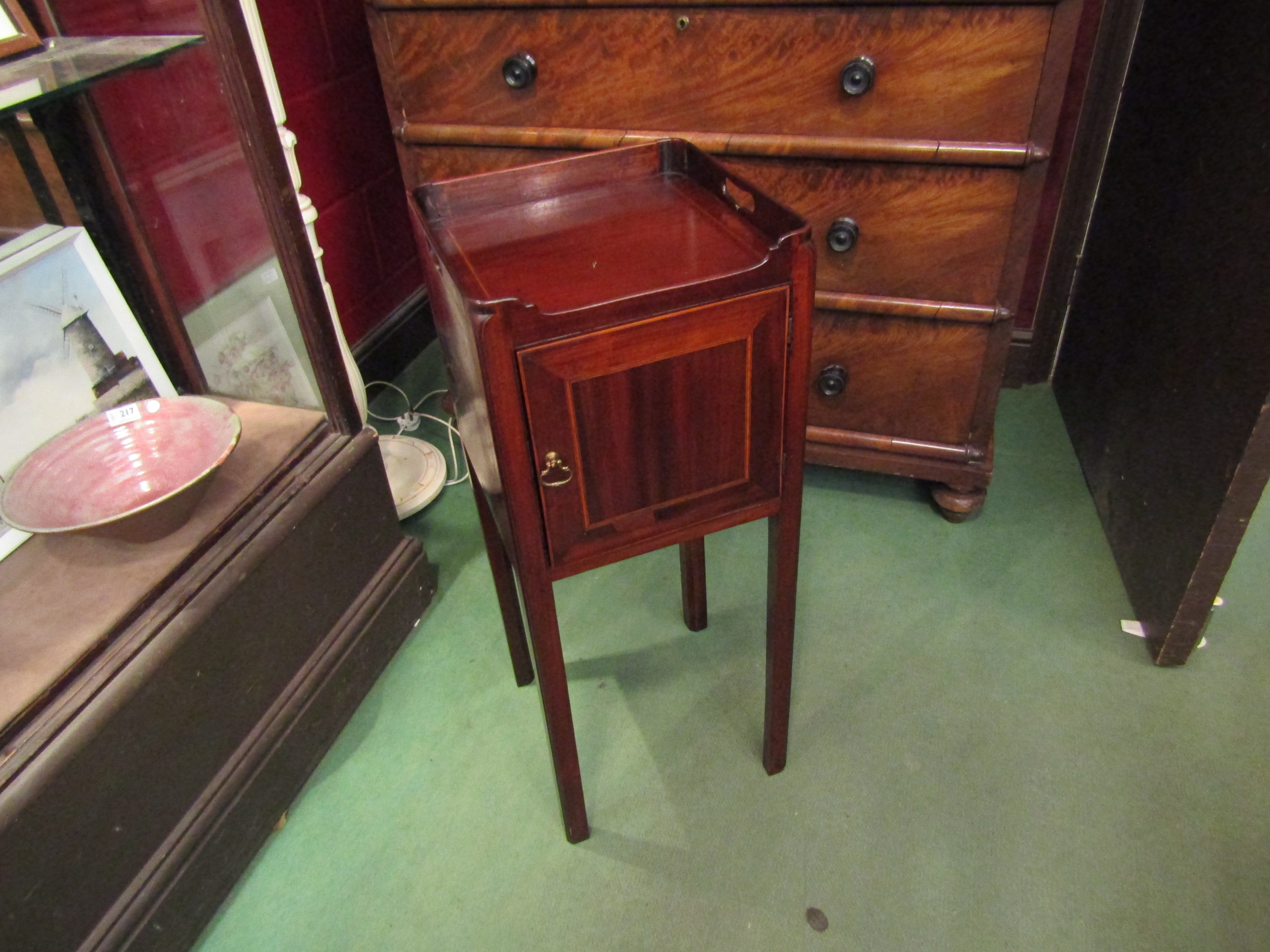 A George III crossbanded mahogany nightstand with fret handles to a raised gallery over a single