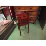 A George III crossbanded mahogany nightstand with fret handles to a raised gallery over a single