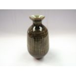A studio pottery bottle vase with ash glaze and vertical line detail. Incised marks to base.