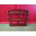 A 19th Century mahogany three tier wall hanging shelf with wavy supports and raised gallery back