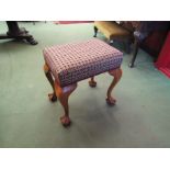 A 19th Century walnut stool the upholstered seat over ball in claw cabriole legs,