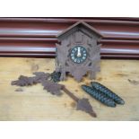 A small modern cuckoo clock in a wood-effect resin case