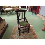 A late Victorian oak child's chair with spindle back over ring turned legs and stretchers