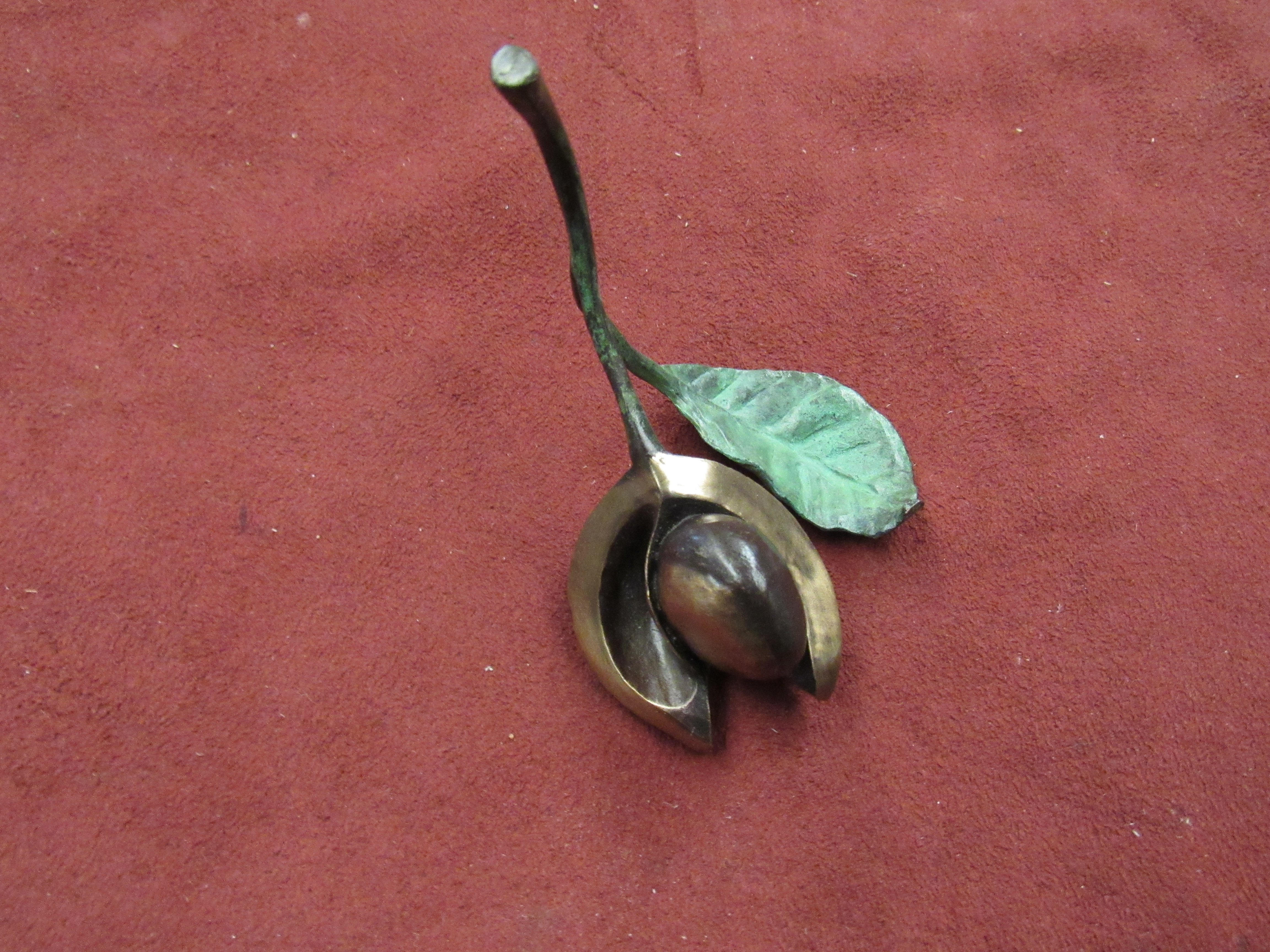 A limited edition cold painted bronze conker with leaf,