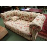 A Victorian two seater button back drop arm Chesterfield sofa on bun feet and castors (with scatter