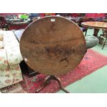 A George III mahogany tilt top wine table on turned column to tripod base