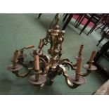 A heavy brass eight branch electrolier with Rococo motifs and cherub masks.