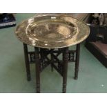 A folding Eastern table with brass charger top