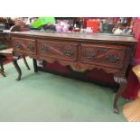 A 19th Century oak sideboard/dresser base with highly carved drawers and chamfered front cabriole