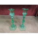 A pair of Victorian green cut glass candlesticks (different heights)
