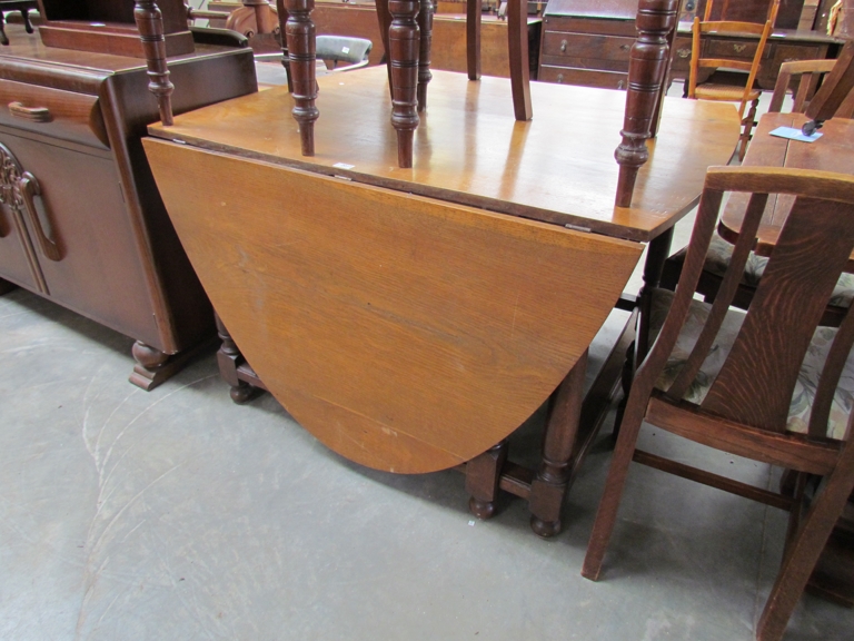 A large 18th Century style honey oak oval-top gate-leg dining table with turned legs 122 x 238cm