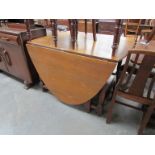 A large 18th Century style honey oak oval-top gate-leg dining table with turned legs 122 x 238cm