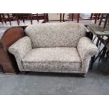 A late Victorian upholstered two seater cottage sofa,