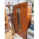 A 1920's oak wardrobe, central mirrored door with panelled sides,